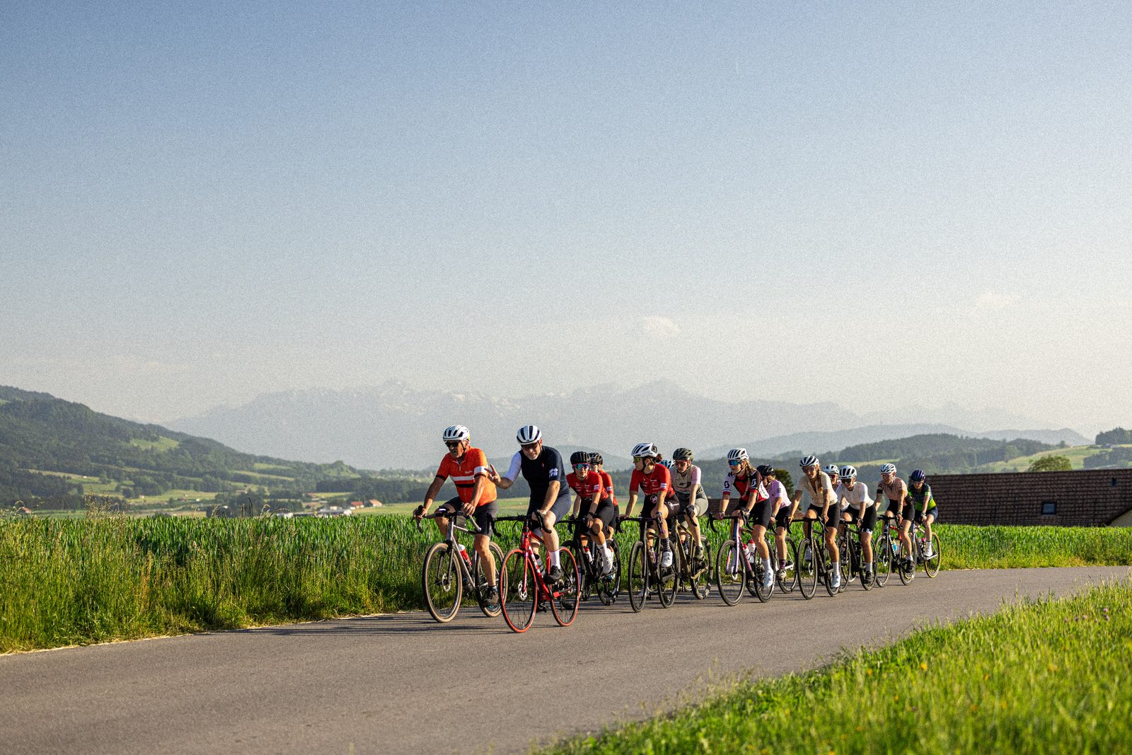 Cycliste sur une route d'été en Gruyère — sélection vélo L'Été en Jaune chez Castella Sports